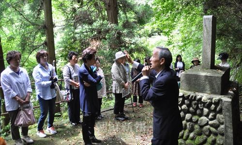 「朝鮮人殉難病没者諸精霊」前で説明をうける参加者たち