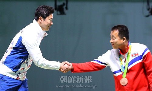 表彰式で握手を交わすキム選手(右)とチン選手