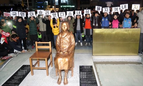 昨年12月30日に行われた、釜山日本総領事館前の少女像の除幕式のようす(聯合ニュース)