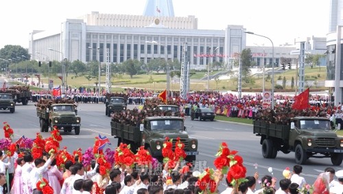 閲兵式終了後、市内をパレードする参加者と笑顔で手を振る市民たち（朝鮮中央通信＝朝鮮通信）