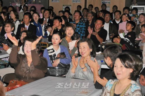 원아, 학생, 학부모들이 피로하는 기념공연에 절찬을 보내는 참가자들.